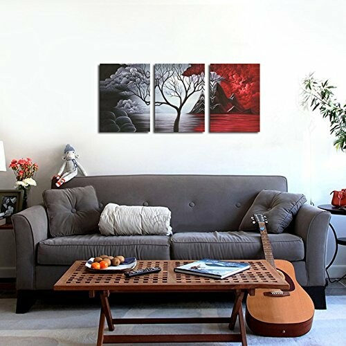 Living room with gray sofa, abstract art, and acoustic guitar.