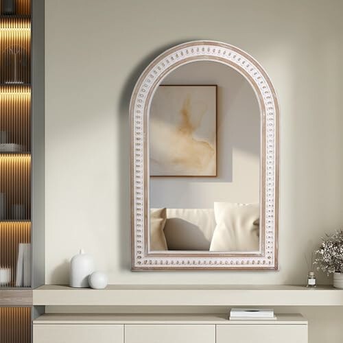 Arched wall mirror with decorative frame in modern room