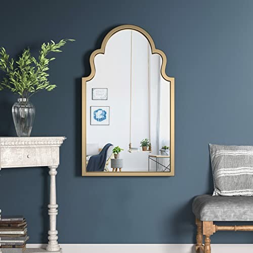 Arched wall mirror on blue wall with decorative table and chair