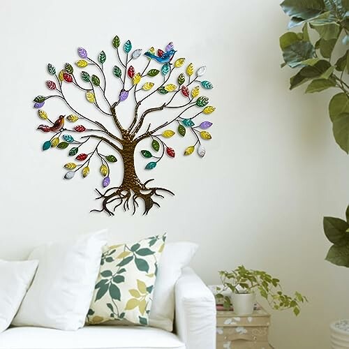 Colorful metal tree wall art with birds above a white sofa.