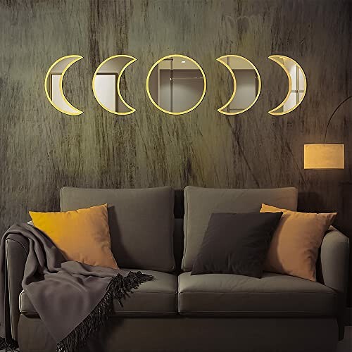 Decorative crescent moon mirrors above a sofa with pillows and a lamp.