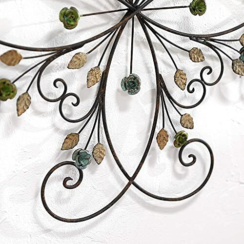 Intricate metal wall art with floral and leaf design.