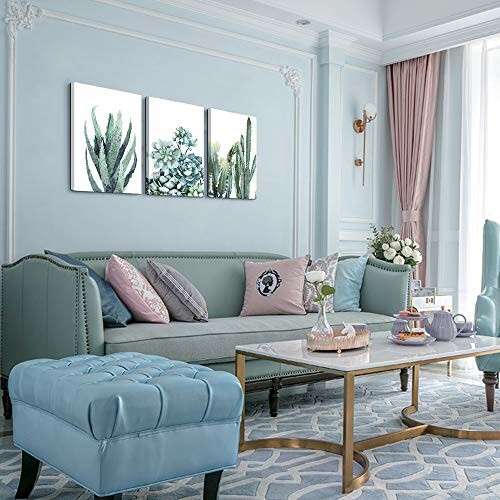 Elegant living room with green sofa, blue ottoman, and floral wall art.