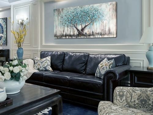 Elegant living room with black leather sofa and artwork.