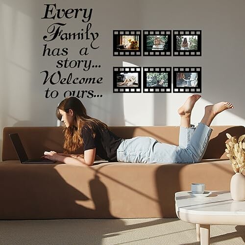 Woman on sofa using laptop with family story wall decor.