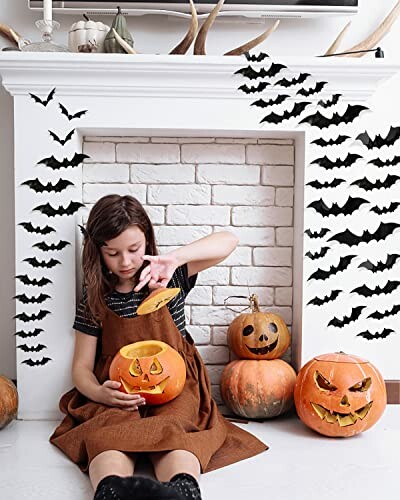 Girl carving pumpkin with Halloween bat decorations.