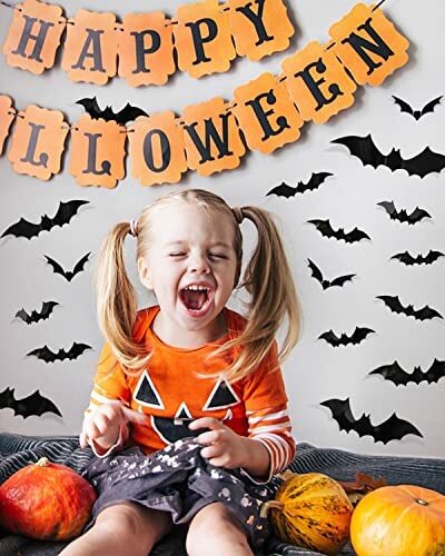 Child in pumpkin shirt with Halloween banner and bats