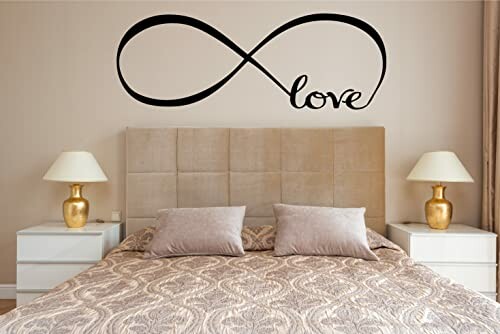 Bedroom with infinity love wall decal above bed, flanked by lamps on bedside tables.