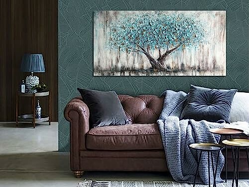 Living room with a brown sofa, decorative pillows, and a large tree painting on the wall.