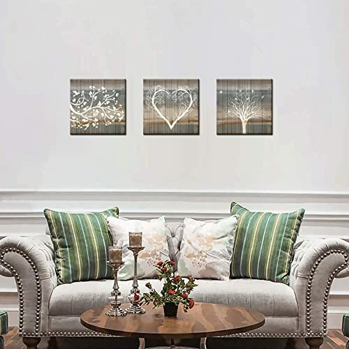 Living room with three wall art pieces above a sofa and a table with flowers.