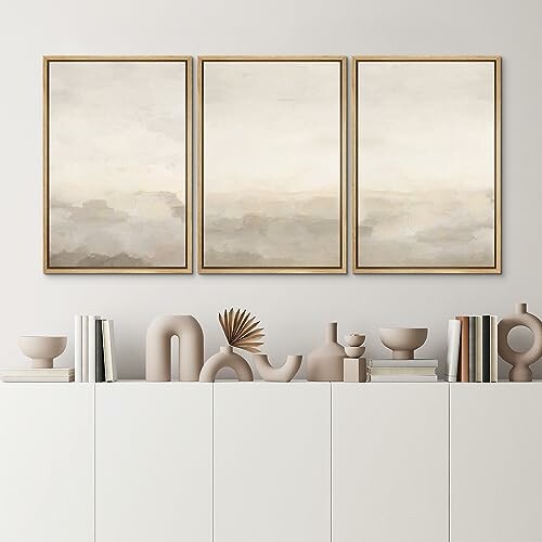 Minimalist beige abstract triptych and pottery on shelf.