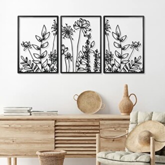 Minimalist floral wall art above a wooden cabinet with decor.