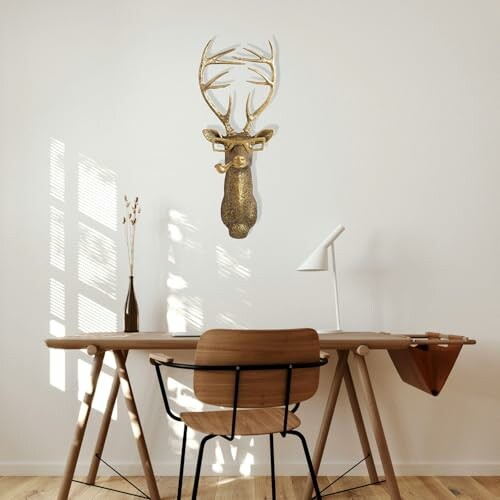 Minimalist home office with wooden desk and decorative deer head on wall.