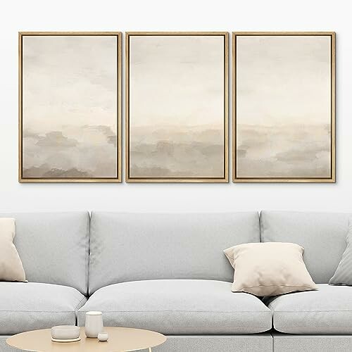 Minimalist living room with abstract triptych art above a light gray sofa.