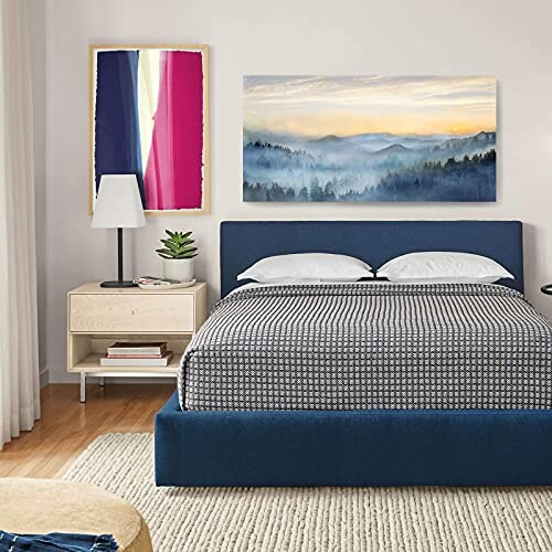 Modern bedroom with blue bed, abstract wall art, and bedside table.