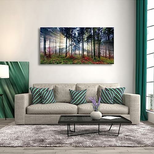 Modern living room with forest art on wall and striped pillows.