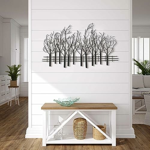 Modern wall art of metal trees above a console table in a living room.