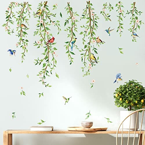 Wall decal of birds on hanging branches with a small plant on a table.