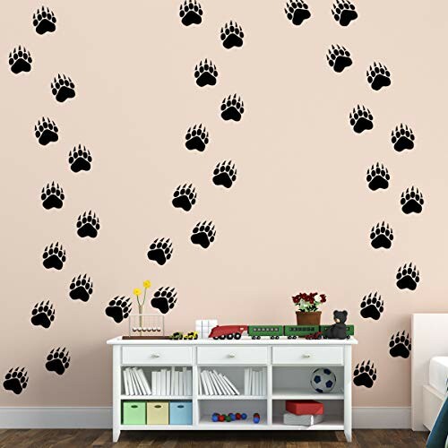 Wall with black paw print decals above a white shelf.