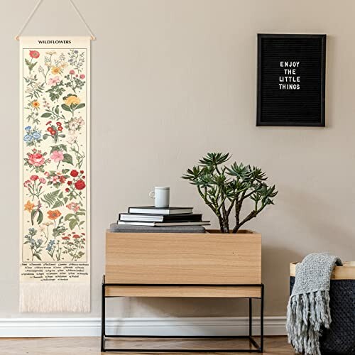 Botanical wall art with wildflowers next to a plant and books.